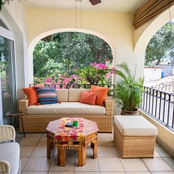 Colorful outdoor seating in a ocean view condo terrace with a balcony.
